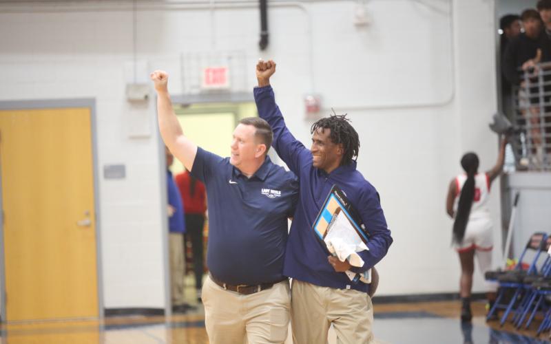 Head Coach Josh Jones (left) and Assistant Coach Donald Bolton (right) celebrate with the traveling Elbert fans after the Lady Devils pulled off an upset of No. 1 seed Oglethorpe in the first round of the GHSA State Playoffs. (Photo by Wells)