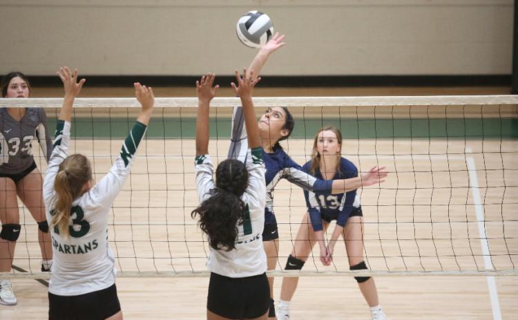 America Vargas spikes the ball as two Athens Academy players try to block her shot in Elbert’s 2-0 loss to the Spartans Aug. 24. (Photo by Wells)