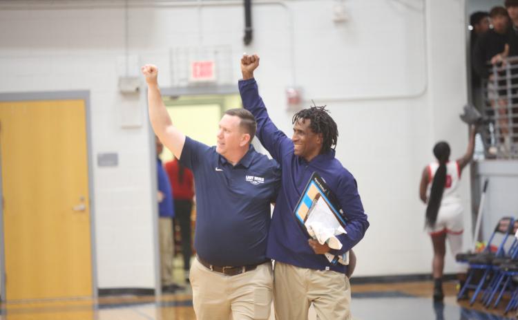 Head Coach Josh Jones (left) and Assistant Coach Donald Bolton (right) celebrate with the traveling Elbert fans after the Lady Devils pulled off an upset of No. 1 seed Oglethorpe in the first round of the GHSA State Playoffs. (Photo by Wells)