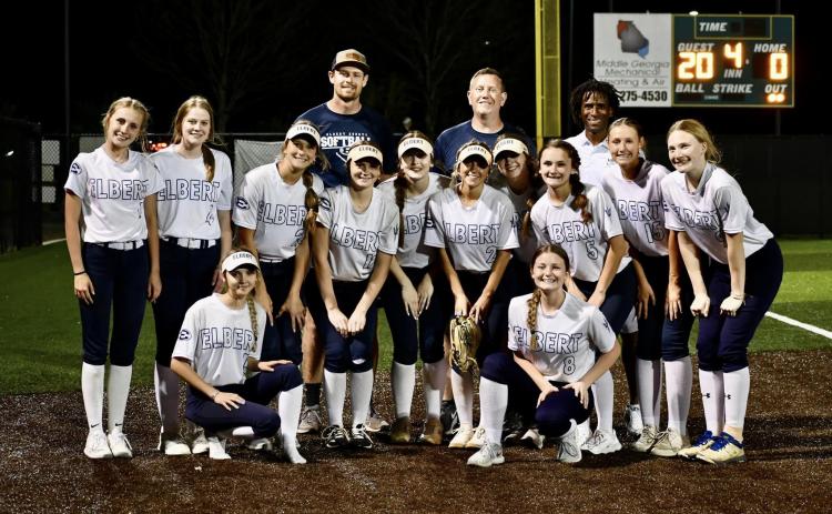 The Lady Devils slow pitch softball team poses in front of the scoreboard after beating LaGrange 20-0 to advance to the Elite Eight round of the GHSA State Playoffs. (Photo courtesy of Elbert County True Blue)